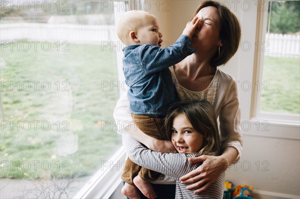 Mother and children playing at window