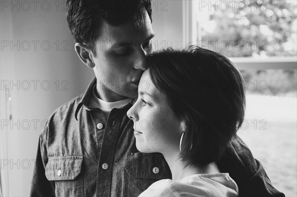 Couple kissing near window