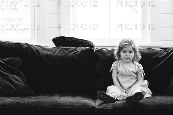 Smiling girl sitting on sofa