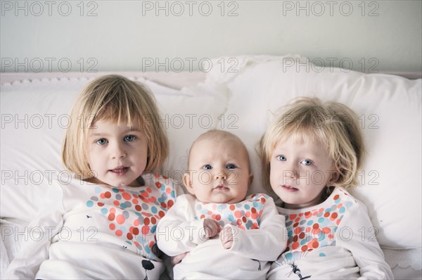 Sisters in matching shirts laying on bed