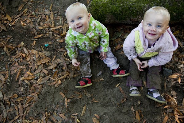 Children smiling on forest ground