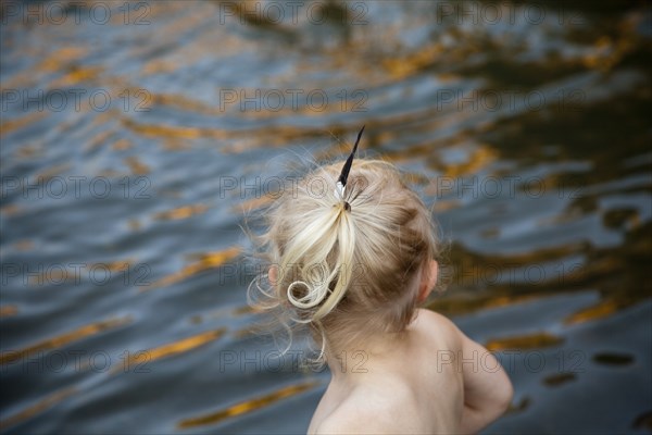 Rear view of girl playing at lake