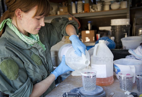 Entrepreneur pouring liquid in workshop