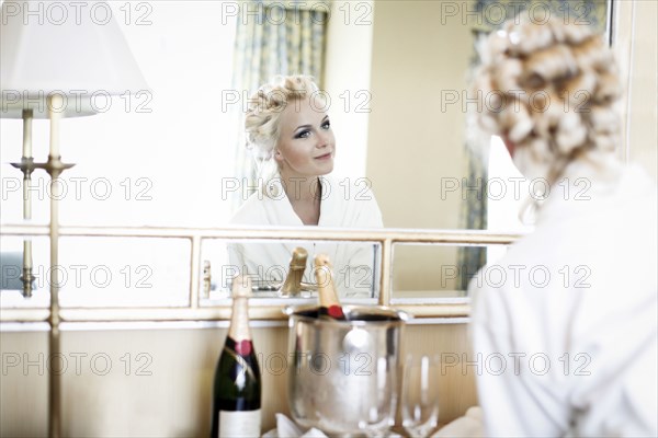 Caucasian woman admiring her hair in mirror