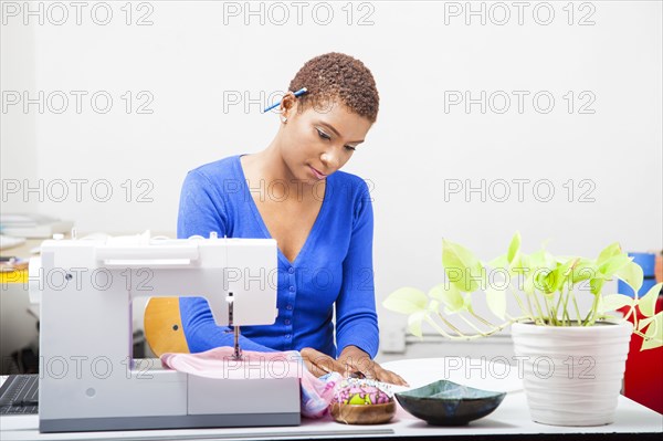 Black dressmaker using sewing machine