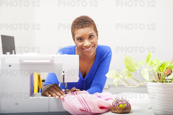Black dressmaker using sewing machine