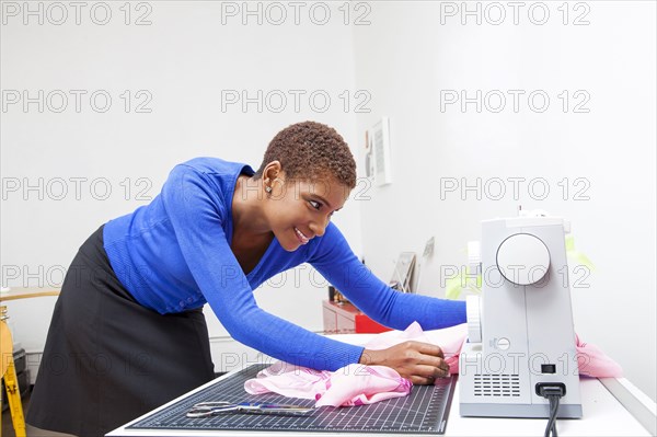 Black dressmaker using sewing machine