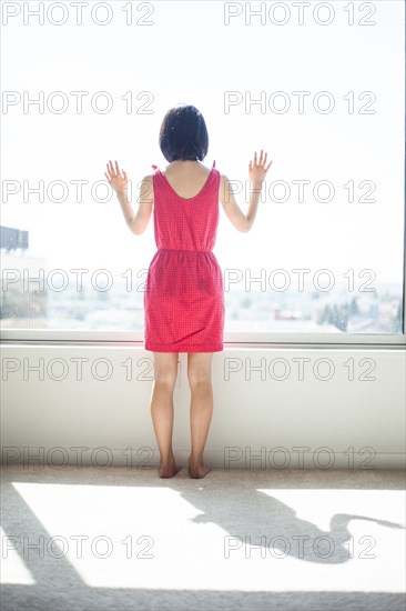 Asian woman looking out window