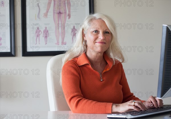 Caucasian chiropractor working at computer