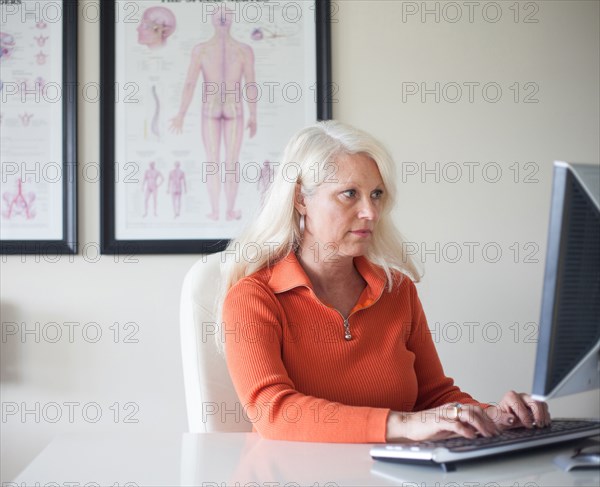 Caucasian chiropractor working at computer
