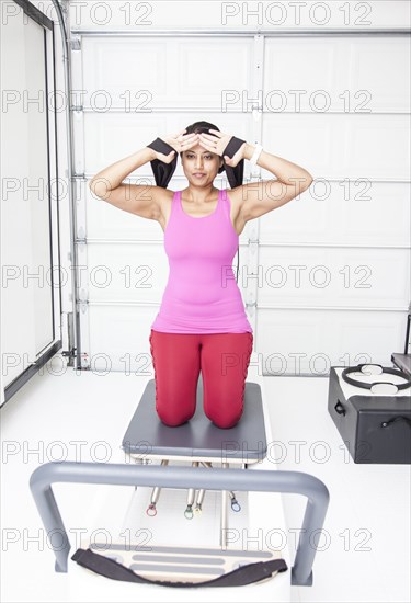 Asian woman using exercise machine in gymnasium