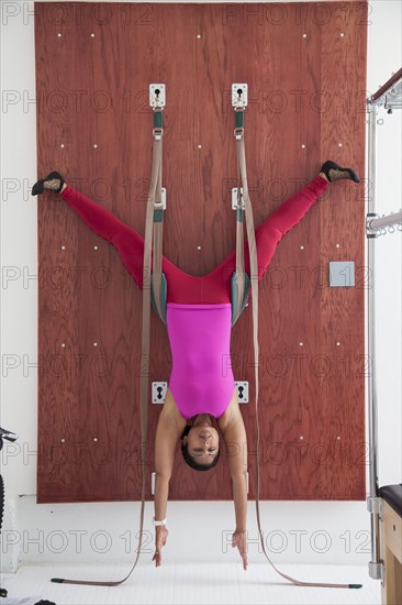 Asian woman using exercise equipment in gymnasium