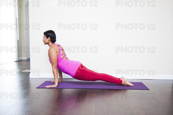 Asian woman practicing yoga in studio