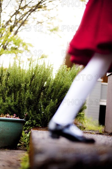 Defocused view of girl wearing red dress on staircase