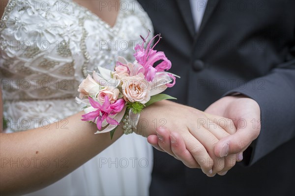 Close up of teenage couple holding hands in prom attire