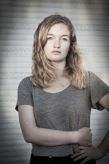 Serious woman standing with hand on hip