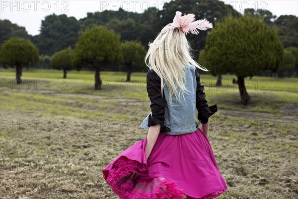 Stylish woman walking in rural field