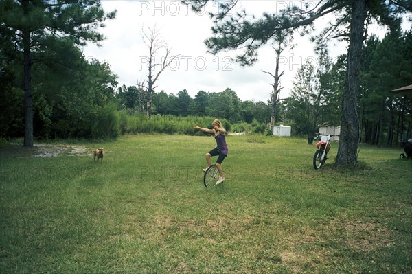 Girl playing on unicycle in field