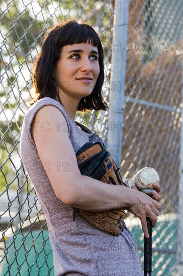 Baseball player leaning on fence