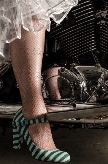 Stylish woman wearing high heels on motorcycle