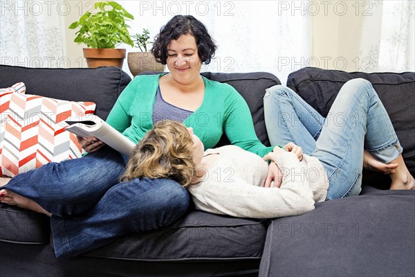 Lesbian couple relaxing on sofa in living room