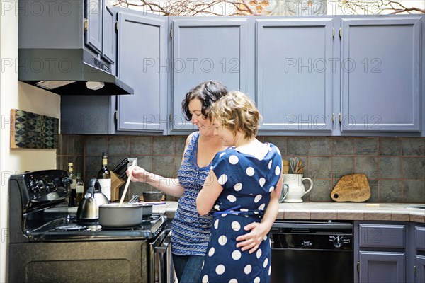 Lesbian couple cooking in kitchen