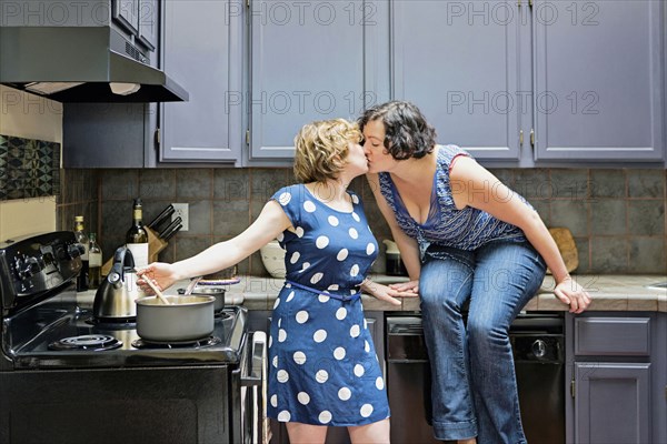 Lesbian couple cooking in kitchen