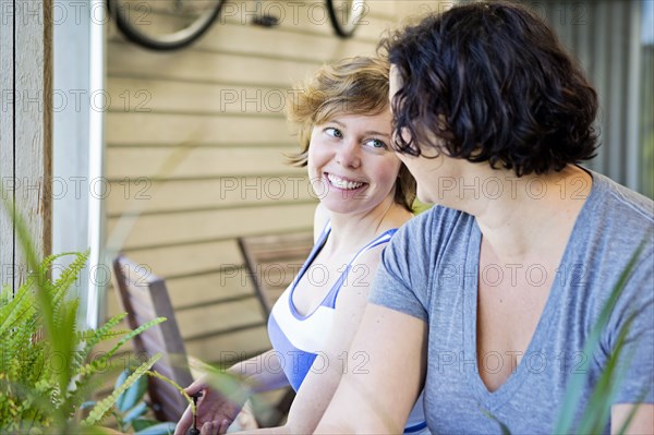 Lesbian couple relaxing in backyard