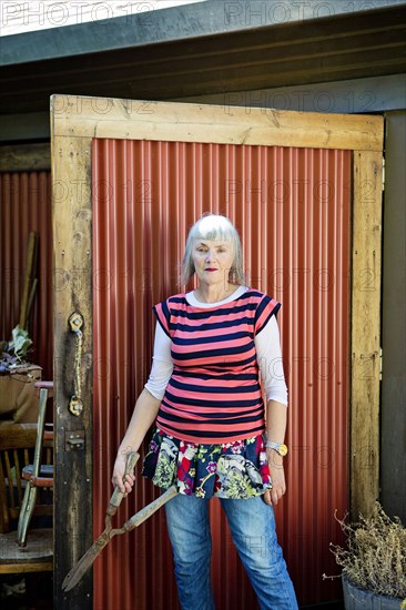 Older Caucasian woman holding shears in backyard