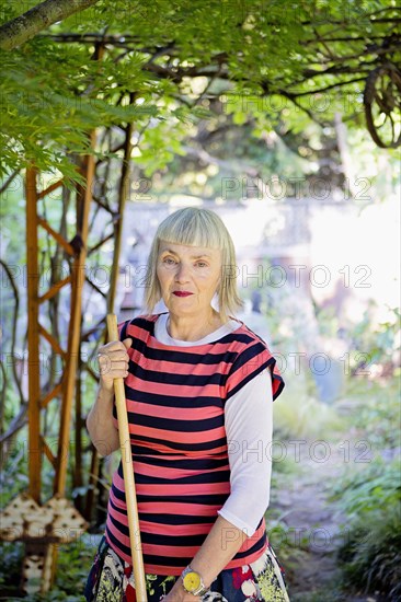 Older Caucasian woman gardening in backyard