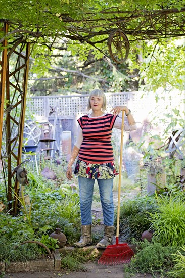 Older Caucasian woman gardening in backyard