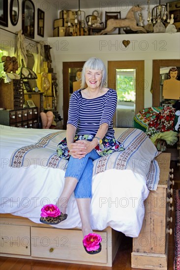 Older Caucasian woman sitting on bed