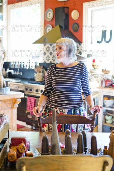 Older Caucasian woman standing at table in kitchen