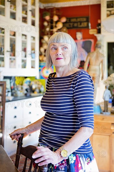 Older Caucasian woman standing at kitchen table