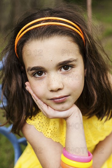 Close up of pensive girl resting chin in hand