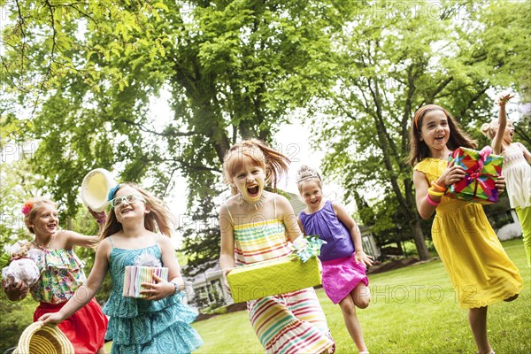 Girls carrying gifts at birthday party