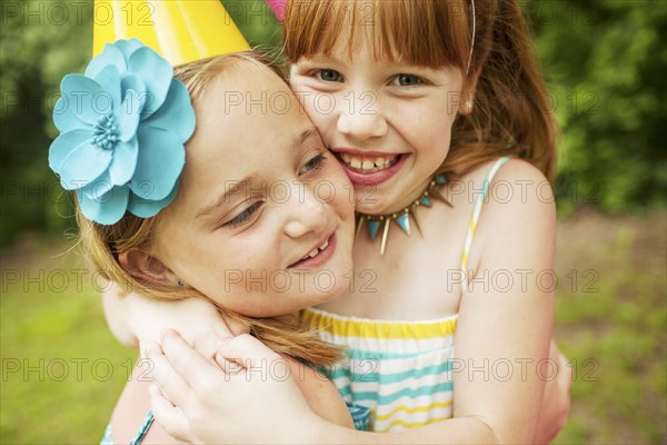 Girls hugging at birthday party outdoors