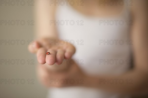 Close up of Caucasian girl holding ladybug