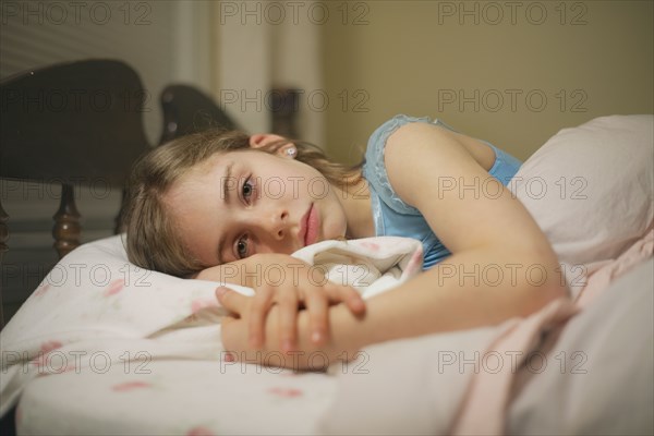 Sleepy Caucasian girl laying on bed