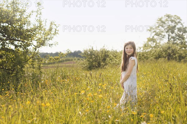 Caucasian girl standing in rural field