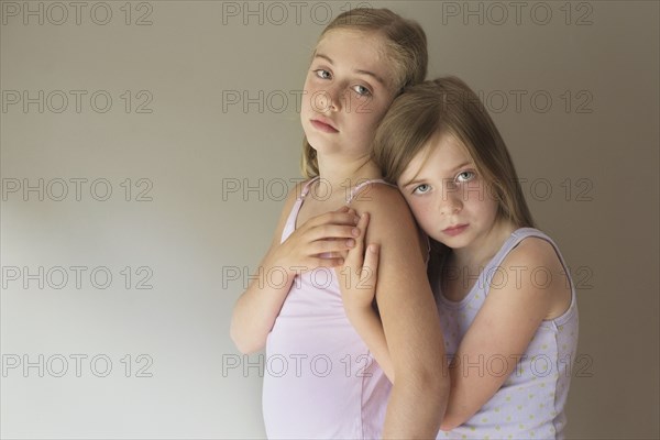 Serious Caucasian girls hugging