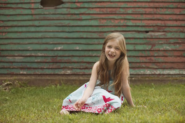 Caucasian girl sitting in backyard