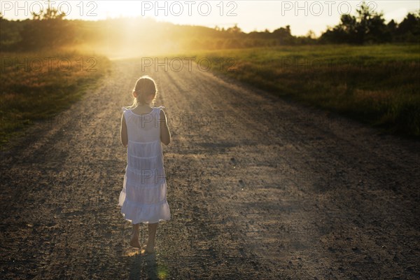 Caucasian girl walking on dirt road