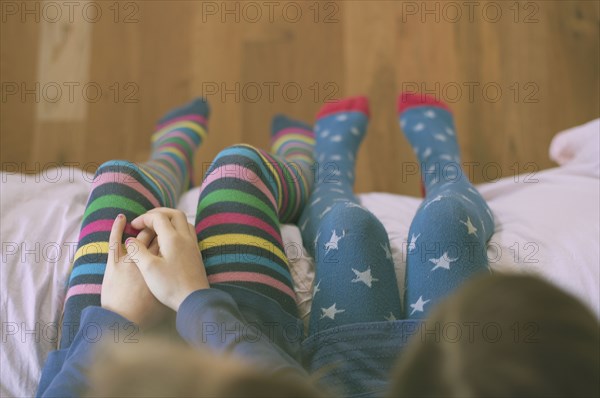High angle view of Caucasian sisters wearing colorful tights