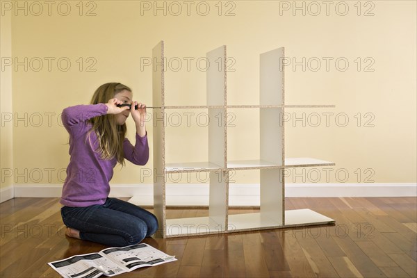 Caucasian girl building bookcase