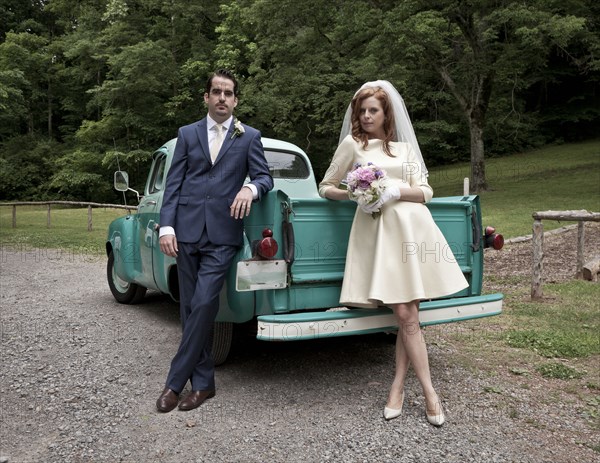 Bride and groom smiling near vintage truck