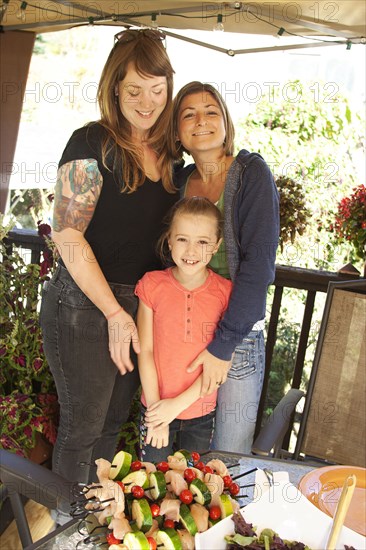 Lesbian couple hugging daughter