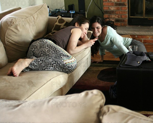 Women using cell phone in living room