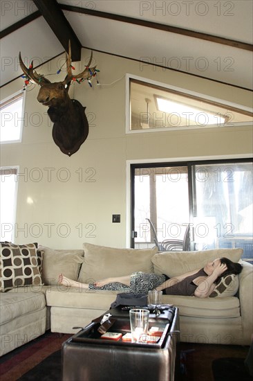 Woman laying on sofa in living room