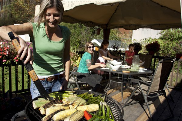 Woman grilling vegetables on patio